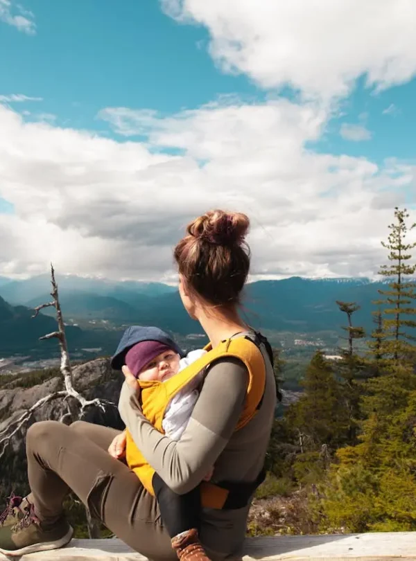 Family-Kid-Friendly-Trips-Mother-Carrying-Her-Baby-while-Looking-at-the-Nature-Scenery.